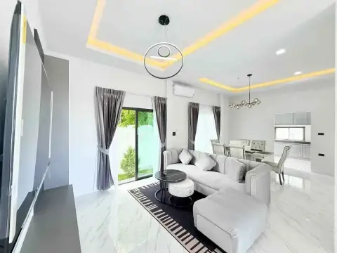 3 Bedroom House for Rent in Mabprachan bright living room with gray sofa and dining area under mood lighting