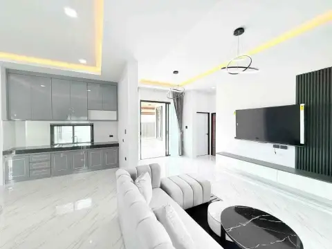 3 Bedroom House for Rent in Mabprachan modern living room with gray kitchen cabinets and wall-mounted TV
