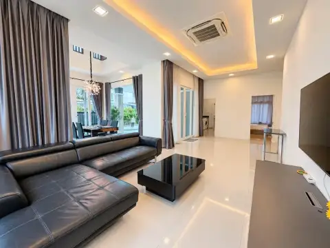 3 Bedroom House for Rent in Mabprachan open-plan living and dining area with black leather sofa