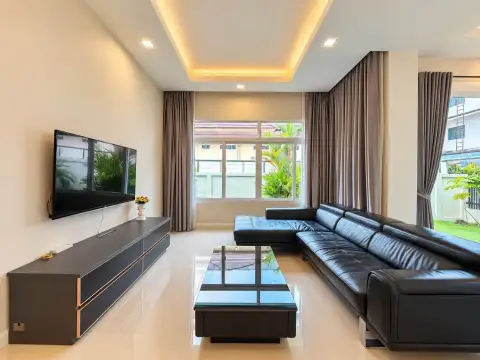 3 Bedroom House for Rent in Mabprachan spacious living room with wall-mounted TV and large windows