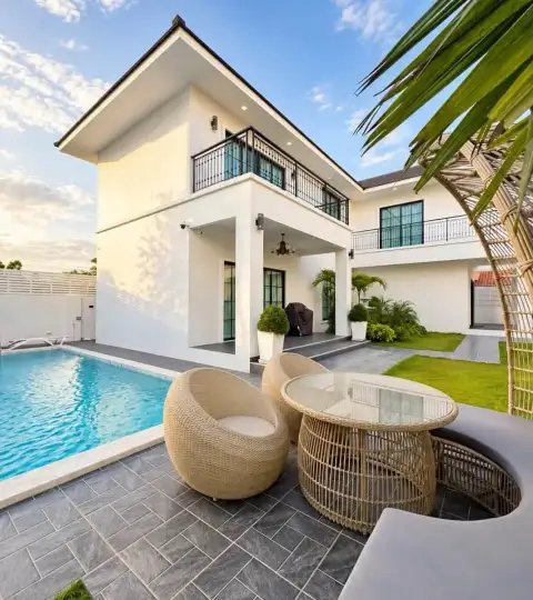6 Bedroom House for Rent in Mabprachan showing poolside patio with rattan furniture and two-story white facade