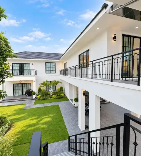 6 Bedroom House for Rent in Mabprachan courtyard with manicured lawn, fountain, and upper balcony walkway
