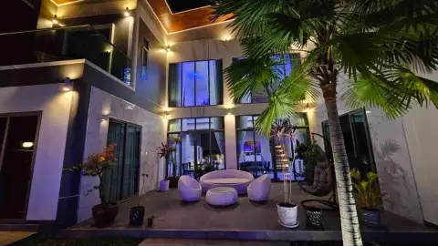 6 Bedroom House for Rent in Mabprachan illuminated two-story exterior with palm trees and rattan patio seating