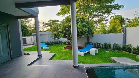 6 Bedroom House for Rent in Mabprachan backyard garden with blue sun loungers and covered patio
