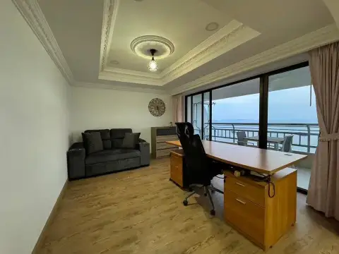 1 Bedroom Condo for Sale at Metro Jomtien Condotel home office with wooden desk, sofa and ocean-view balcony