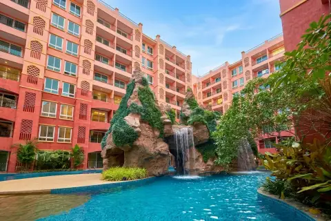 Seven Seas Condo Resort swimming pool with rock waterfall feature and lounge chairs beside the building