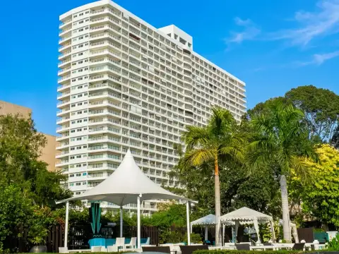 View Talay 6 condo building exterior with tented poolside pavilion and palm trees