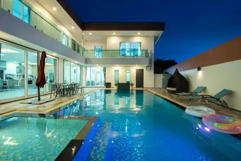 8 Bedroom House for Rent in Na Kluea poolside with floats and lounge chairs at dusk
