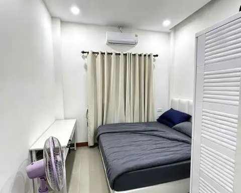 2 Bedroom Townhouse for Rent in Na Kluea second bedroom with gray bedding, desk, fan and closet