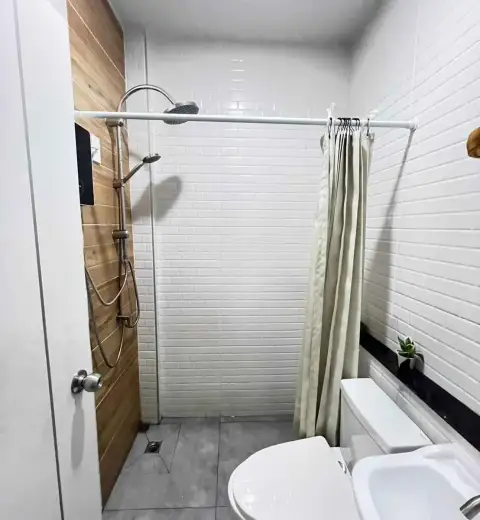 2 Bedroom Townhouse for Rent in Na Kluea walk-in shower with rainfall showerhead and wood accent wall