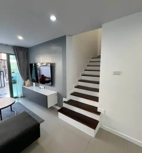 3 Bedroom House for Rent in Na Kluea wooden staircase beside living room with wall-mounted TV