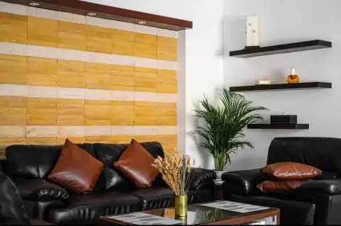 3 Bedroom House for Rent in Na Kluea living room with leather couches, stone accent wall, and shelving