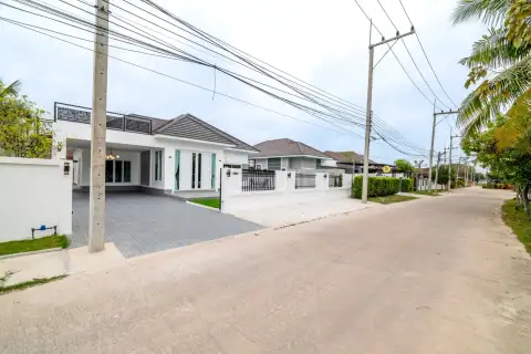 3 Bedroom House for Sale in Nong Pla Lai street view of gated white house with driveway