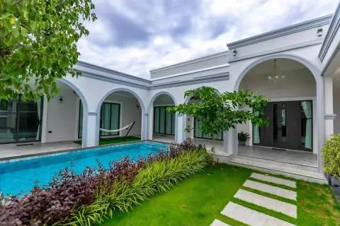 4 Bedroom House for Sale in Nong Prue with garden pathway, lawn and pool alongside arched veranda