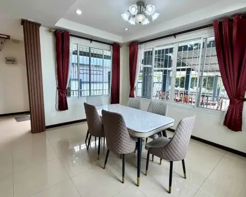 3 Bedroom House for Rent in Nong Prue dining area with marble table, upholstered chairs, and red curtains