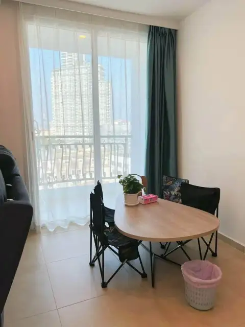 2 Bedroom Condo for Sale at Olympus City Garden dining nook with round table, folding chairs and city view balcony
