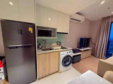 1 Bedroom Condo for Sale at Once Pattaya kitchen with refrigerator, microwave and living room view