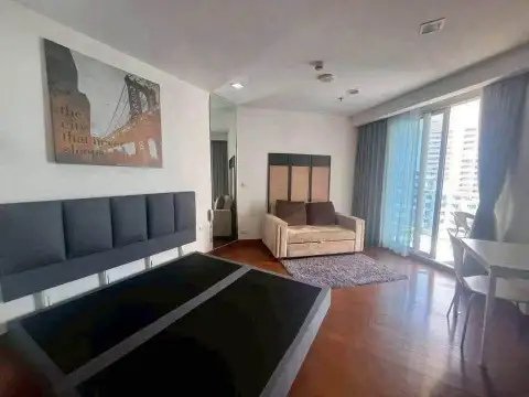 1 Bedroom Condo for Sale at Palm Wongamat bedroom with upholstered bed and city-view balcony