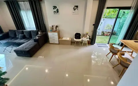 3 Bedroom House for Sale at Patta Define open living room with gray sofa, tiled floor, and garden view
