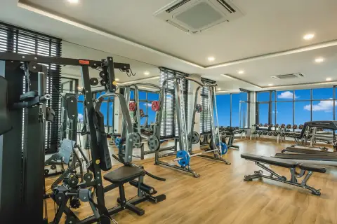 Patta Prime well-equipped fitness center with various weight machines, benches, and mirrored walls.