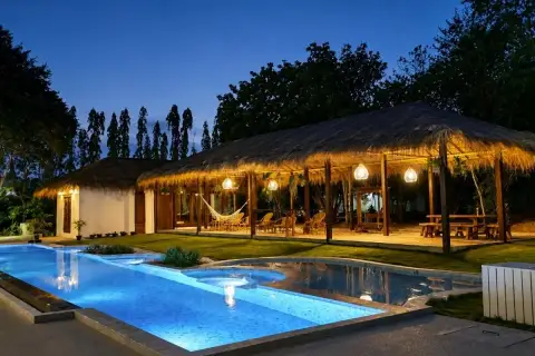 4 Bedroom House for Rent in Huai Yai evening view of pool and thatched-roof outdoor lounge area