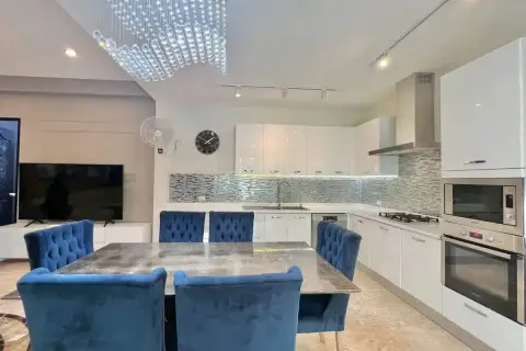4 Bedroom House for Sale at Mountain Village 1 open-plan kitchen and dining area with blue velvet chairs and crystal chandelier