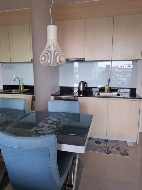 1 Bedroom Condo for Sale at Grande Caribbean kitchen with black countertops and pendant light over dining table