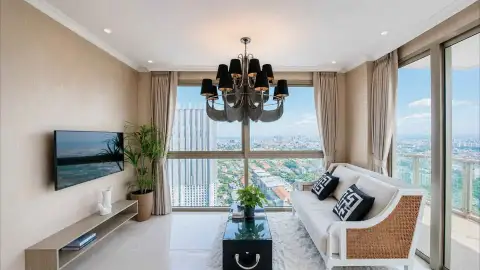 1 Bedroom Condo for Sale at Riviera Ocean Drive living room with rattan sofa, chandelier, and panoramic city views