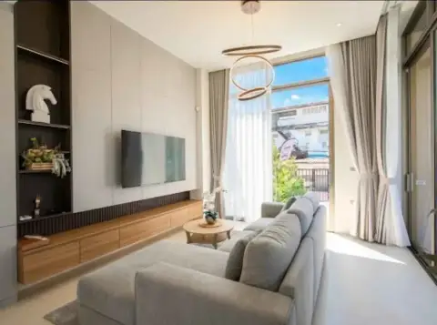 3 Bedroom House for Rent in Central Pattaya bright living room with gray sofa and wall-mounted TV