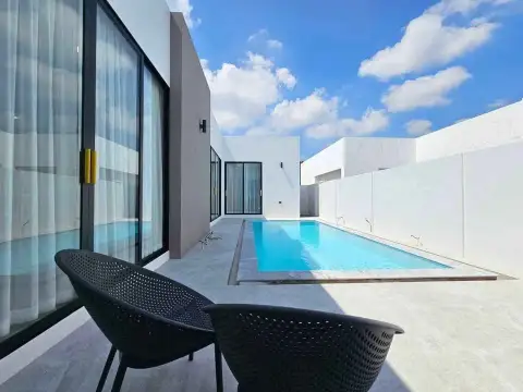 3 Bedroom House for Sale in Pong poolside patio with lounge chairs and sliding glass doors