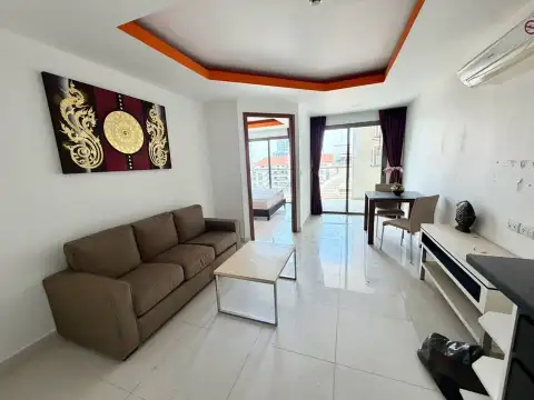 1 Bedroom Condo for Sale at C View Residence 2 living room with brown sofa, dining table and balcony access