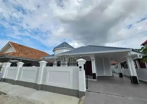 3 Bedroom House for Rent at Pattaya Lagoon Village street view of house behind white perimeter wall and gate