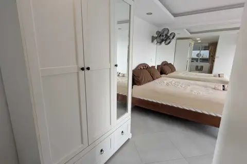 1 Bedroom Condo for Rent at Pattaya Beach Condo white wardrobe with mirror reflecting bed and bedroom interior