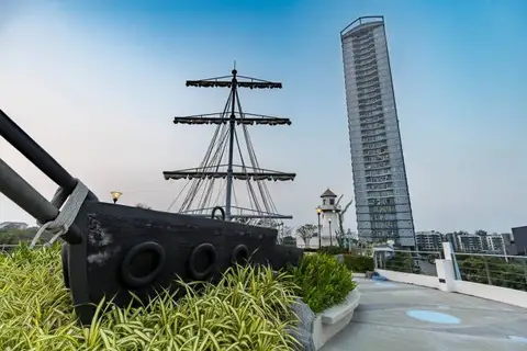 Supalai Mare Pattaya rooftop swimming pool with a white waterslide and a tall residential building.