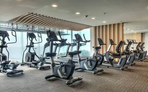 Cetus Beachfront modern gym with various exercise machines and large windows overlooking the ocean.
