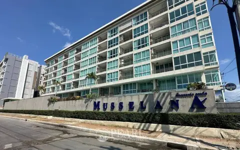 Musselana condo exterior with prominent building name sign, multiple balconies, and lush landscaping.