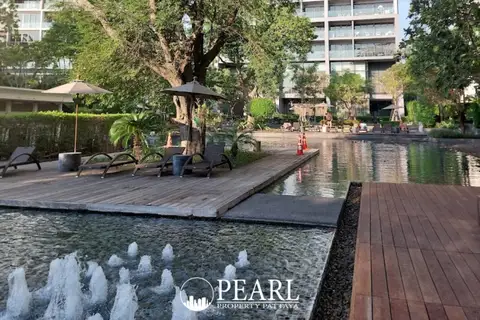 Zire Wongamat outdoor swimming pool area with fountains, wooden decks, and lounge chairs.