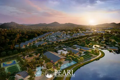 Wisdom First Residences aerial view of the resort-style condo complex with lake, sports courts, and sunset.