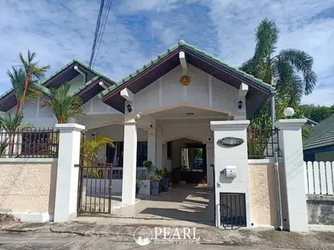 Paradise Hill 2 single-story house exterior with green roof, white pillars, and front gate.