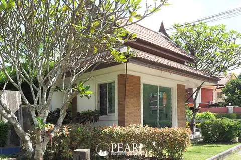 T.W. Wanasin modern white villa with a private swimming pool, green lawn, and multiple balconies.