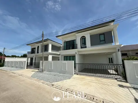 Spring Town Pool Villa Pattaya outdoor patio with a dining set, gravel path, lush greenery, and a small pool.