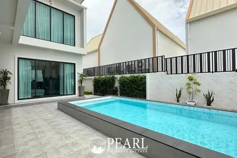 Jin Village backyard with a rectangular private swimming pool, tiled patio, and green hedges.
