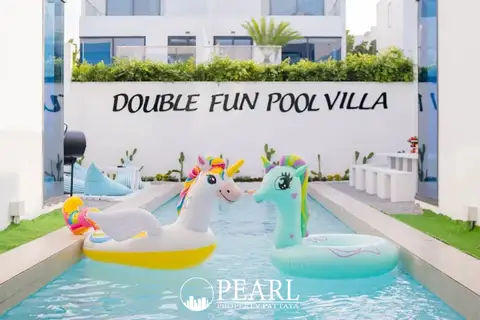 Palm Spring villa Pattaya close-up of a private swimming pool with two large unicorn inflatables and white wall sign.