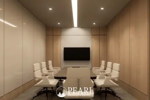 Baan Mae 12 – Onyx Grand Village modern conference room with a large table, white chairs, and wall-mounted TV.