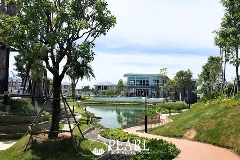 Patta Element outdoor swimming pool with decorative floats, overlooking a lake and modern houses.