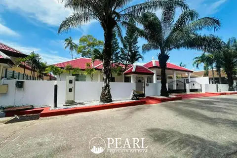 Paragon Park Village street view with white houses, red roofs, palm trees, and a gated entrance.