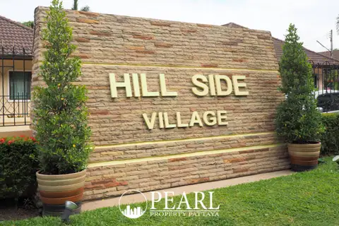 Hillside Village Pattaya modern house exterior with lush green lawn, covered carport, and large windows.