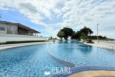 Sliver Beach large outdoor swimming pool with intricate blue tiling, surrounded by green landscaping and a building with a white facade.
