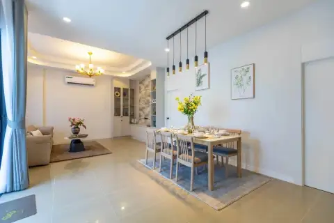 3 Bedroom House for Sale at Phonthep Garden Ville 2 open-plan dining and living area with wood dining table and gold chandelier