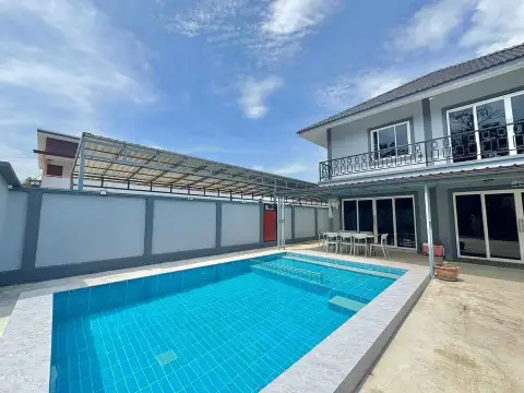 4 Bedroom House for Rent in East Pattaya exterior view with swimming pool and covered patio under blue sky